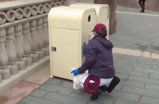 A cast member at Shanghai Disneyland seen cleaning a trash can